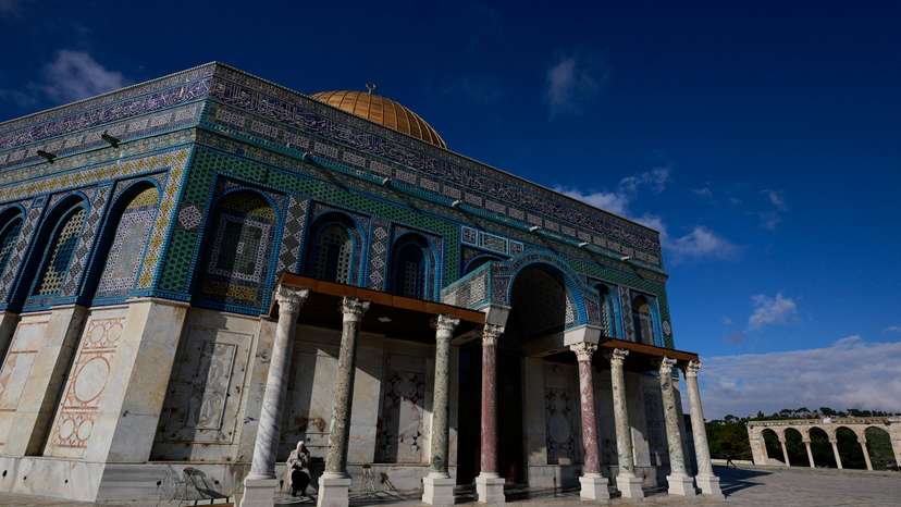 A Palestinian woman rests in front of the Dome of the Rock on Al-Aqsa compound, also known to Jews as the Temple Mount, in Jerusalem's Old City