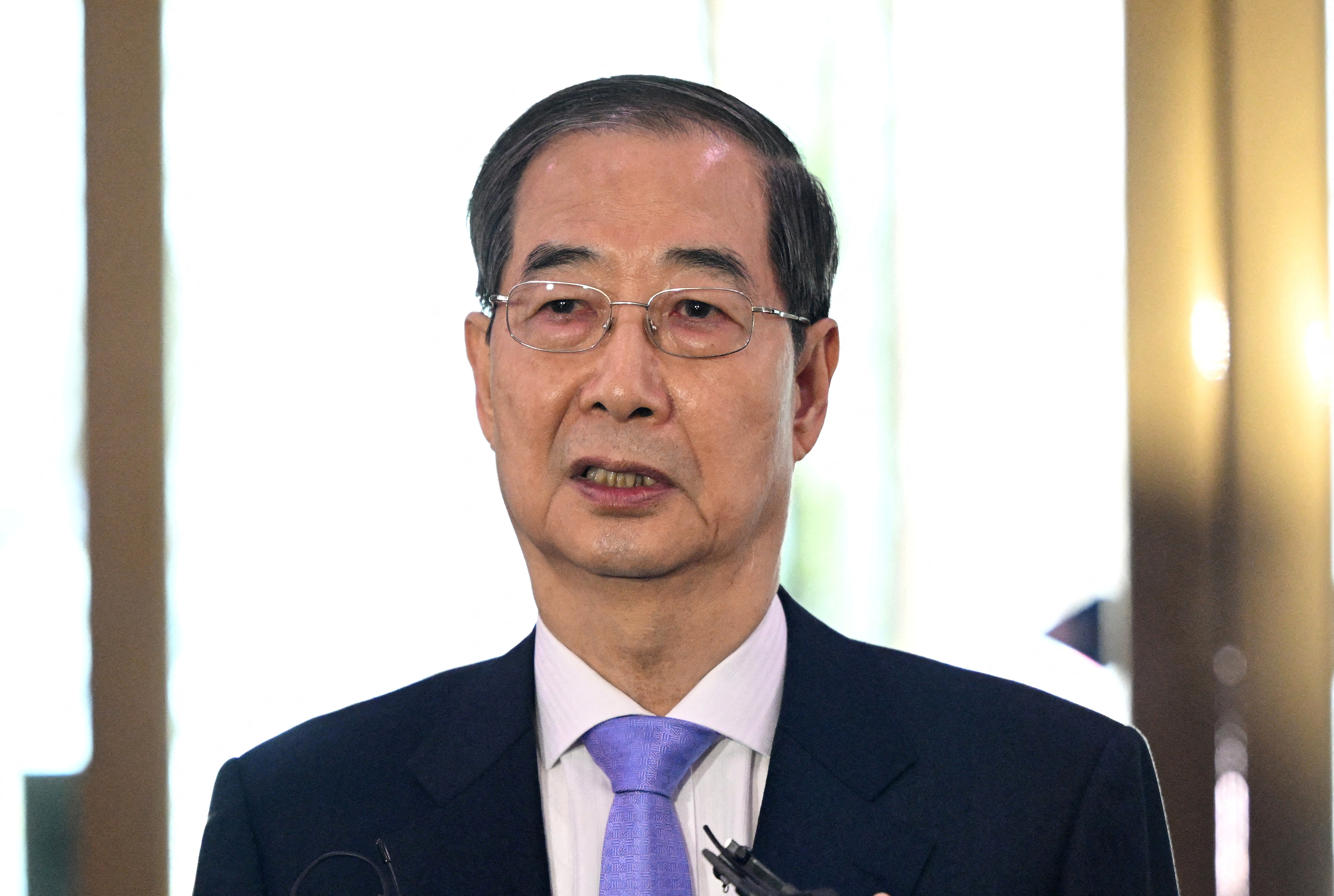 FILE PHOTO: South Korean Prime Minister Han Duck-soo speaks to the media as he arrives at the Government Complex in Seoul