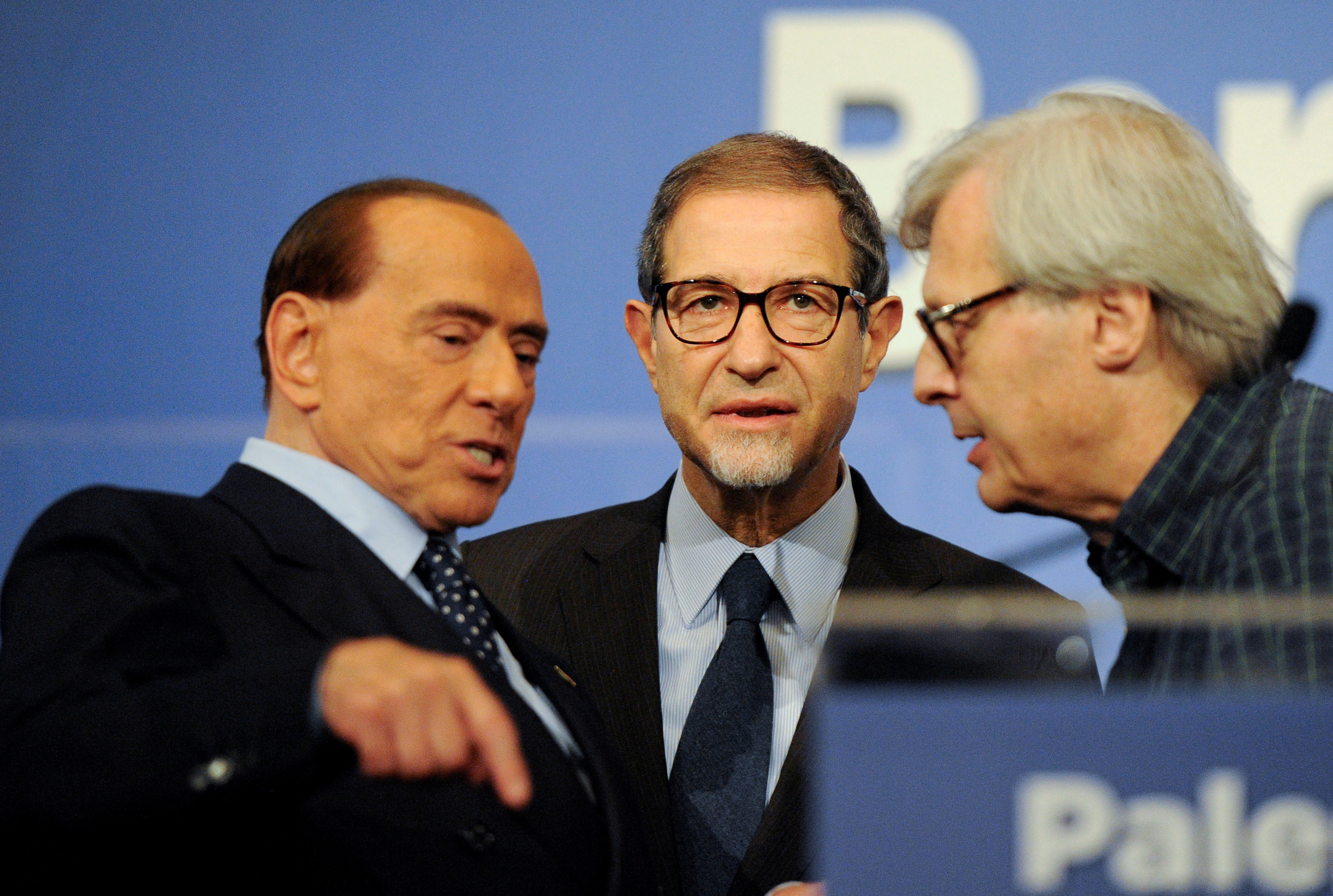 FILE PHOTO: Forza Italia party leader Silvio Berlusconi talks to candidate Nello Musumeci and Vittorio Sgarbi at the end of a rally for the regional election in Palermo