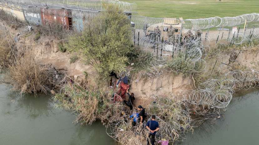 FILE PHOTO: Migrants cross the border into Texas from Mexico