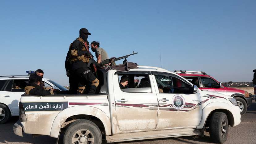 FILE PHOTO: Syrian army personnel travel in a military vehicle as they head towards Latakia to join the fight against the fighters linked to Syria's ousted leader Bashar al-Assad, in Aleppo