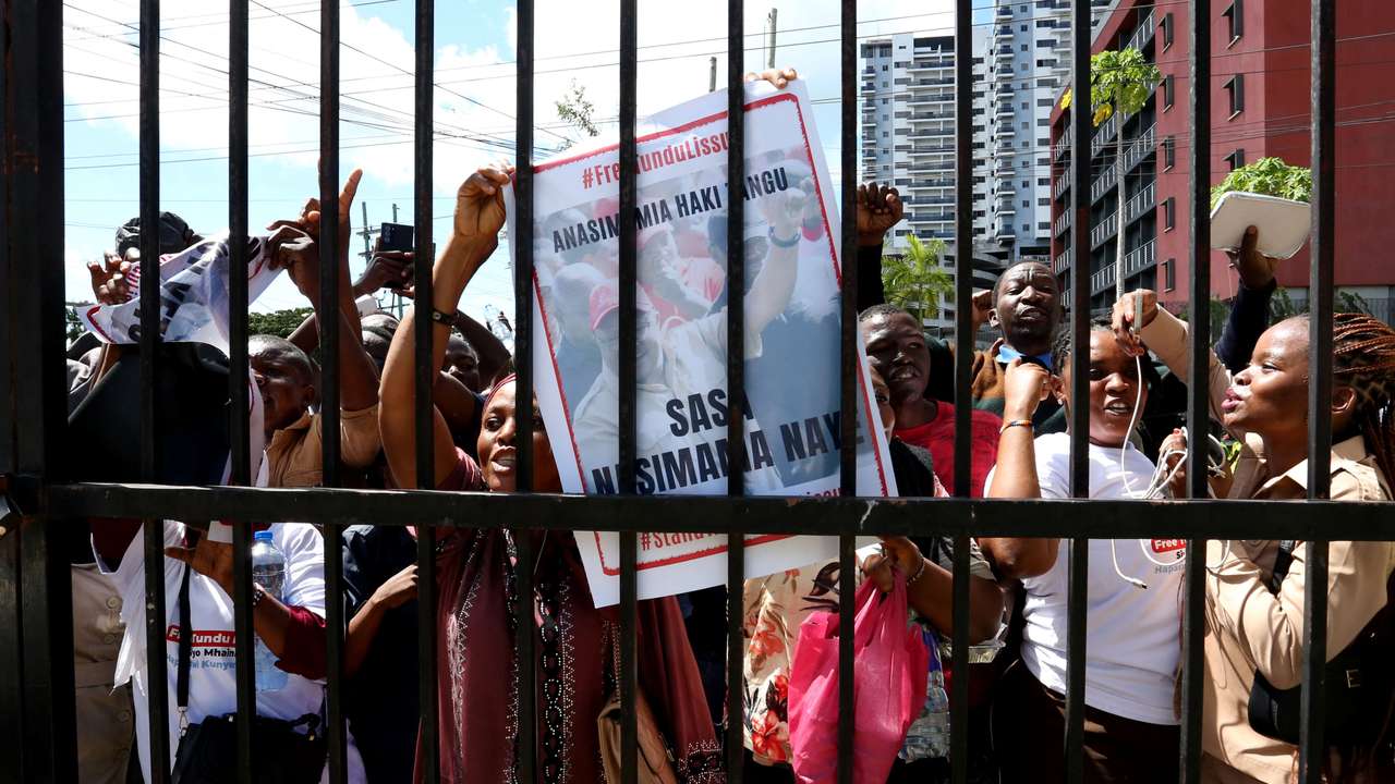 Supporters of Tanzanian opposition leader and former presidential candidate of CHADEMA party Tundu Lissu, chant slogans as they gather outside the Kisutu Resident Magistrate Court in Dar es Salaam