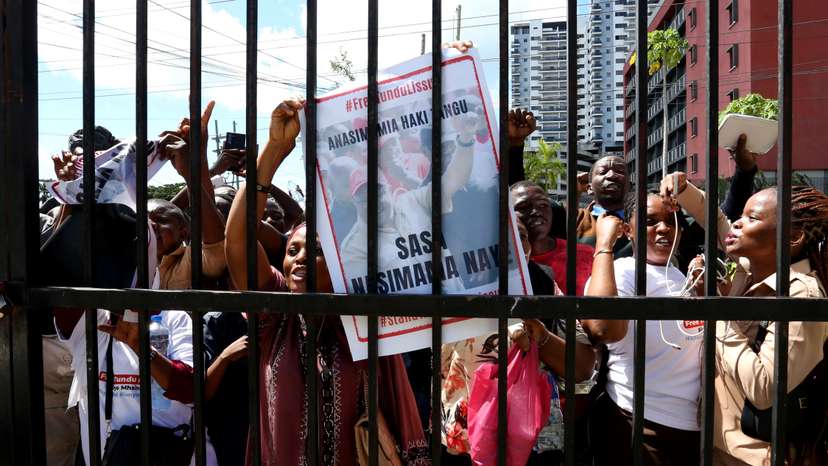Supporters of Tanzanian opposition leader and former presidential candidate of CHADEMA party Tundu Lissu, chant slogans as they gather outside the Kisutu Resident Magistrate Court in Dar es Salaam