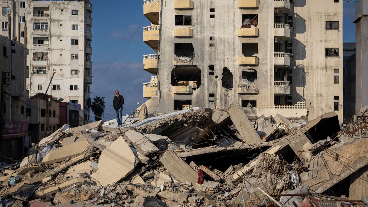 A man stands on the ruins of his house destroyed in an Israeli strike, after the ceasefire between Israel and Hezbollah, in Tyre