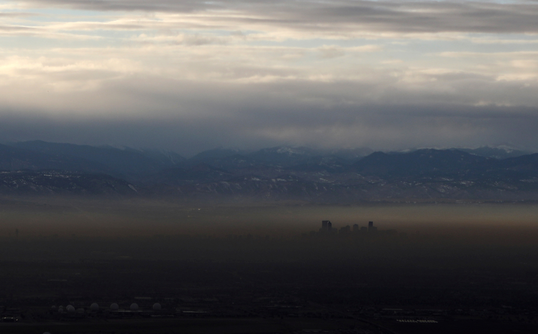 The Rocky Mountains are pictured as a layer of air pollution hangs over Denver, Colorado