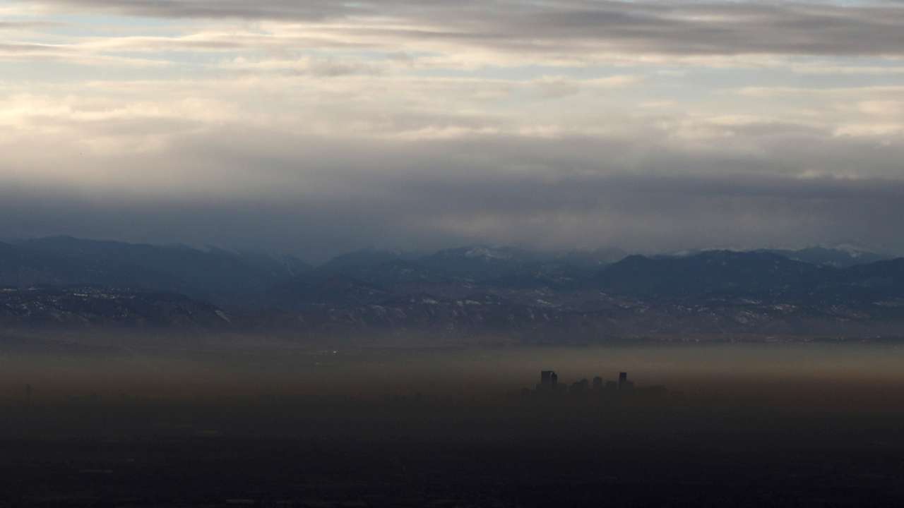 The Rocky Mountains are pictured as a layer of air pollution hangs over Denver, Colorado