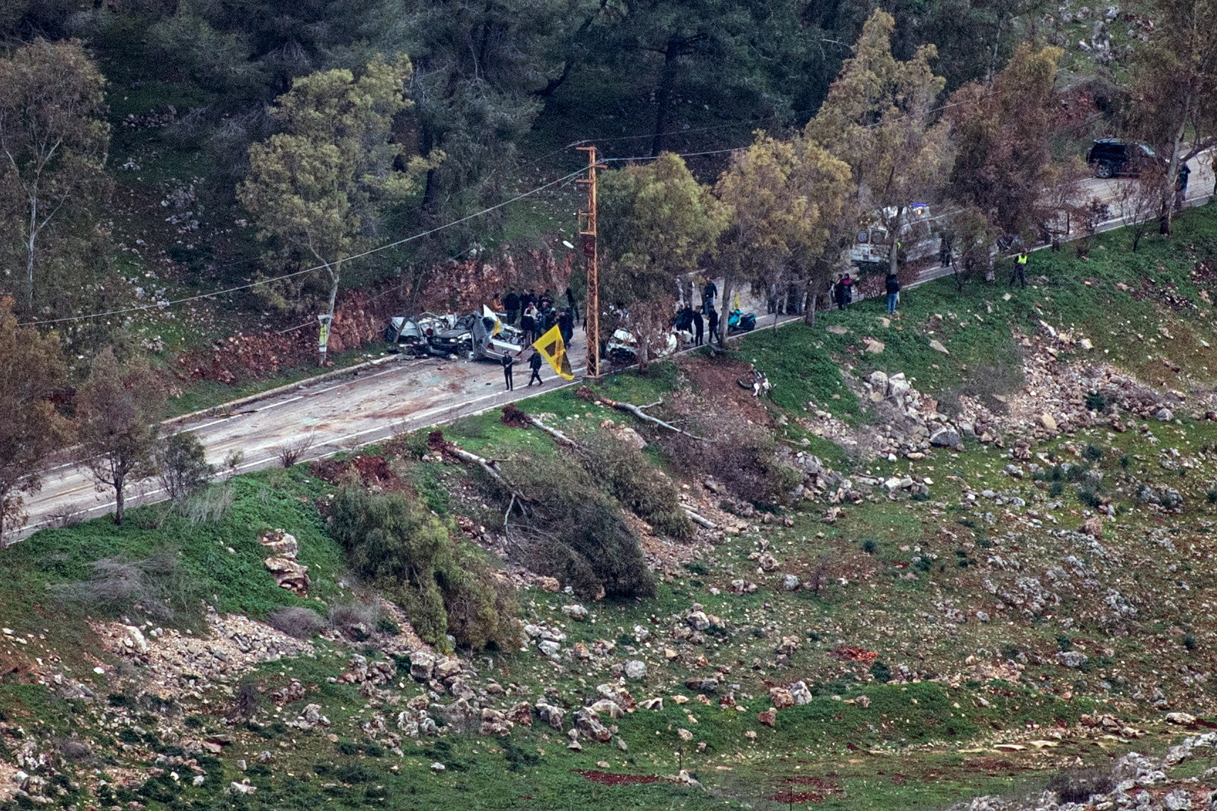An ambulance and people gather on a road in southern Lebanon, after Israel's military said they fired warning shots when they identified suspects approaching Israeli troops, as seen from northern Israel