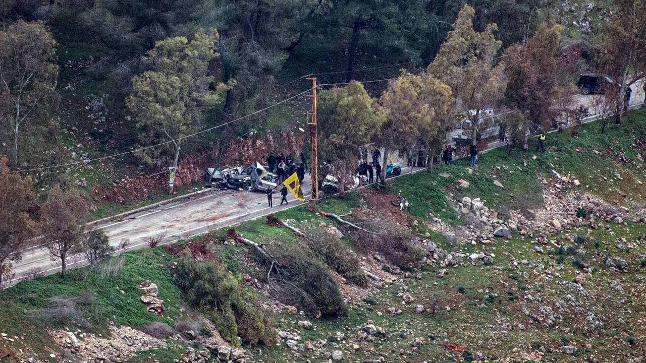 An ambulance and people gather on a road in southern Lebanon, after Israel's military said they fired warning shots when they identified suspects approaching Israeli troops, as seen from northern Israel