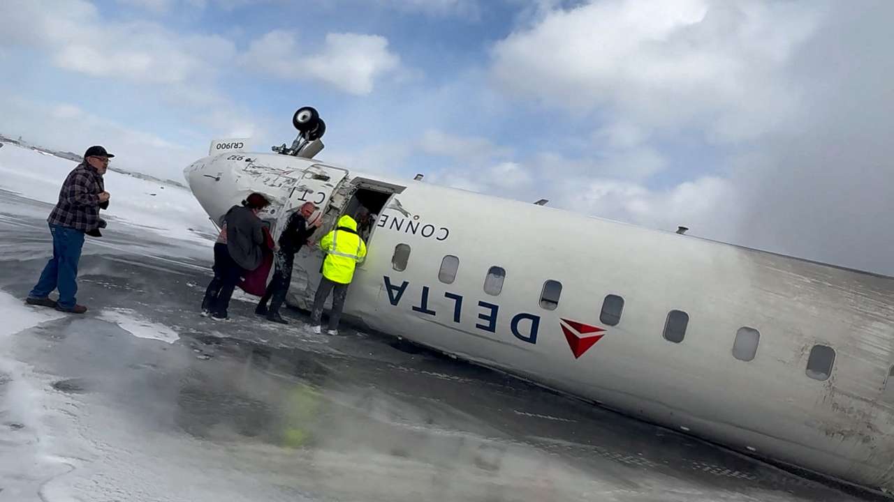FILE PHOTO: Passengers leave a Delta Air Lines CRJ-900 jet after it crashed on landing at Toronto Pearson International Airport