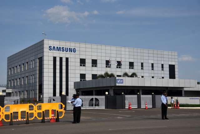 Security guards stand outside a Samsung facility during a strike by the factory workers demanding higher wages in Sriperumbudur