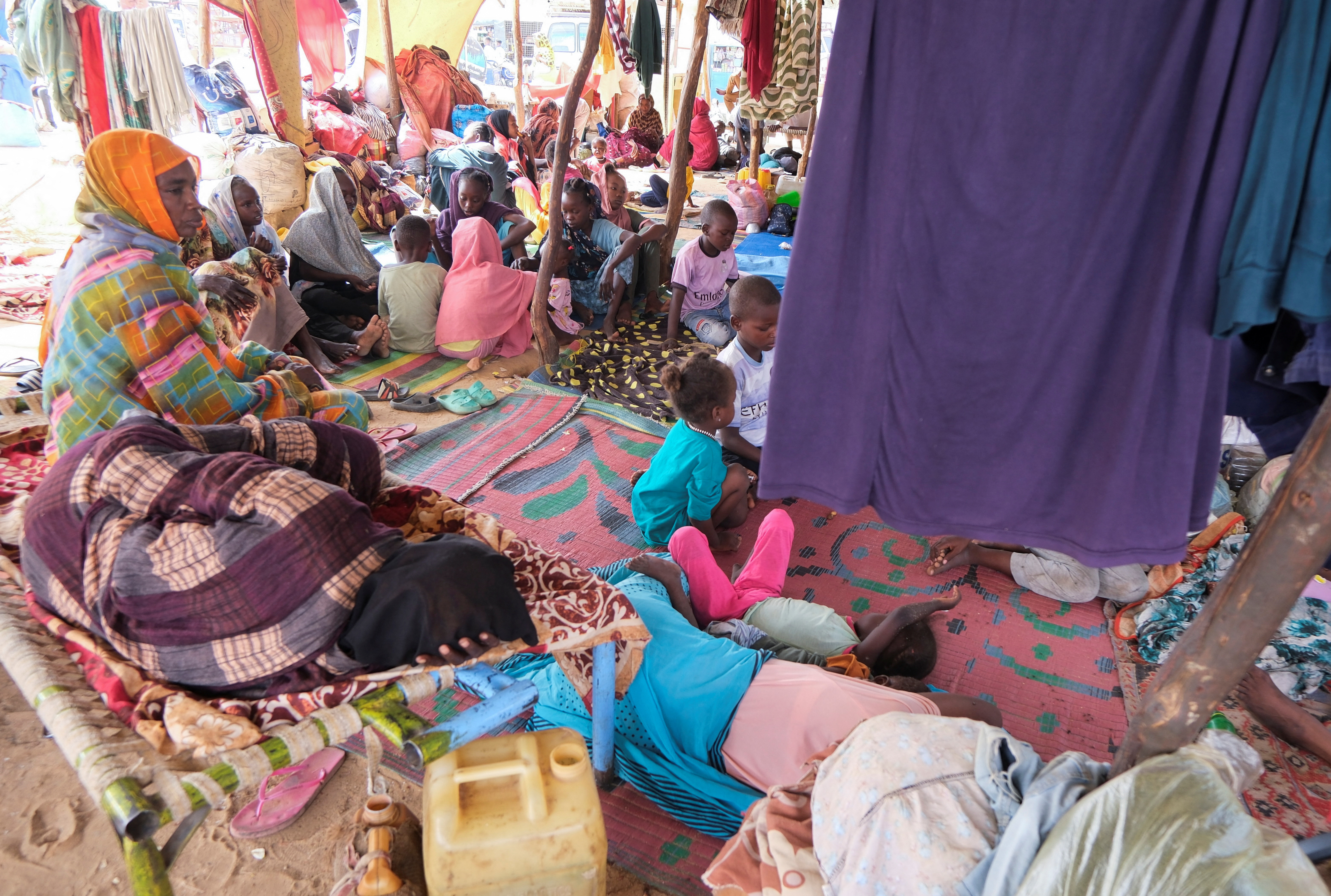 Sudanese women who fled intense fighting in al-Fashir sit on the ground at a displacement camp, in Al Dabba