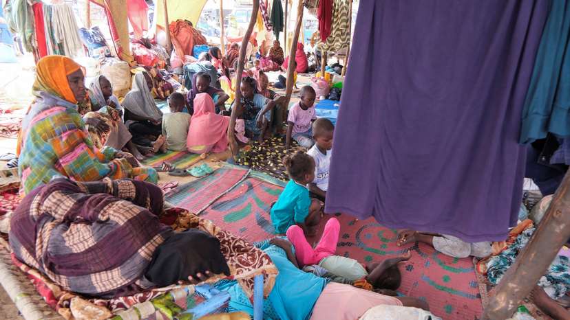 Sudanese women who fled intense fighting in al-Fashir sit on the ground at a displacement camp, in Al Dabba