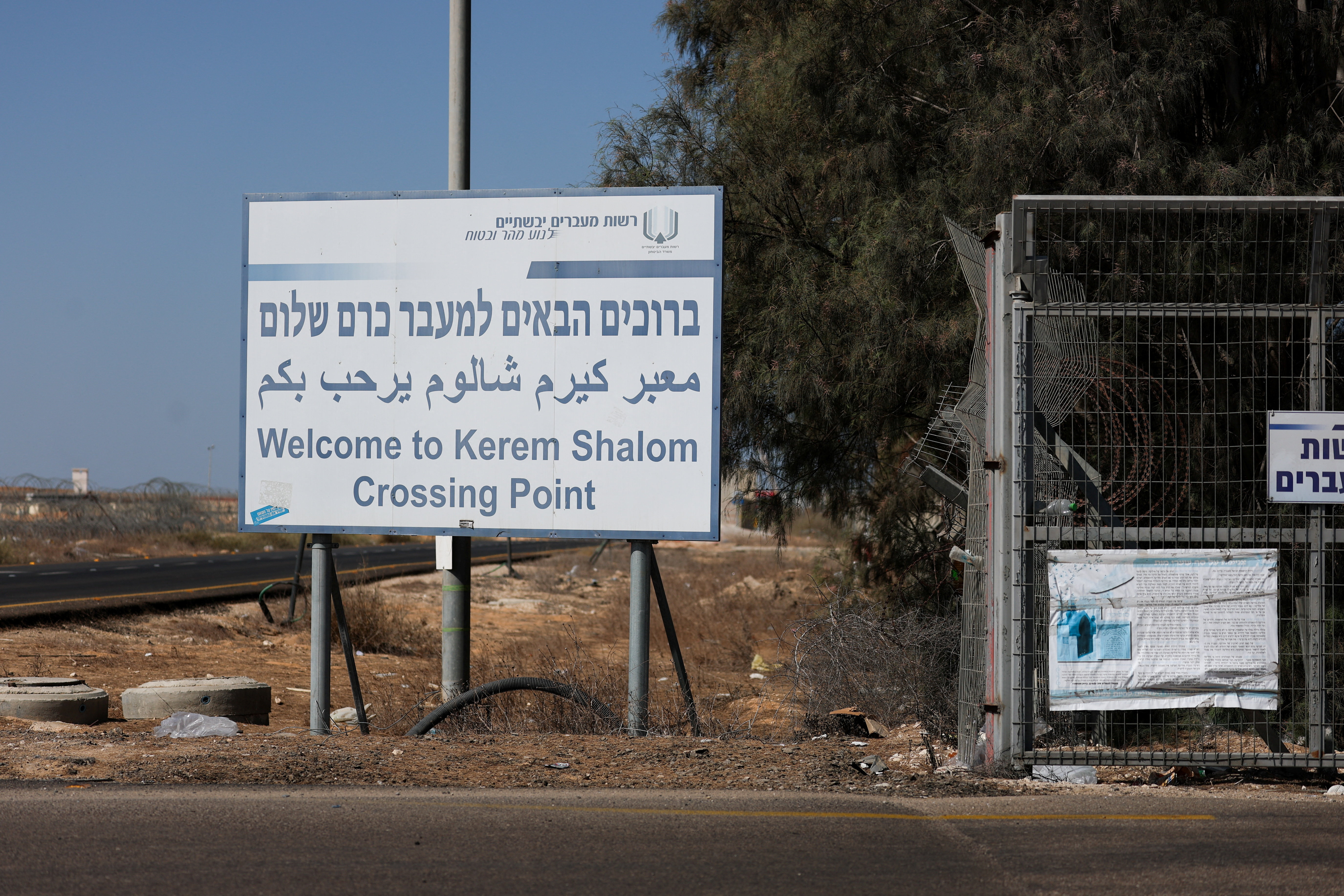Trucks carrying aid wait at the Israeli side of the Kerem Shalom border crossing to southern Gaza