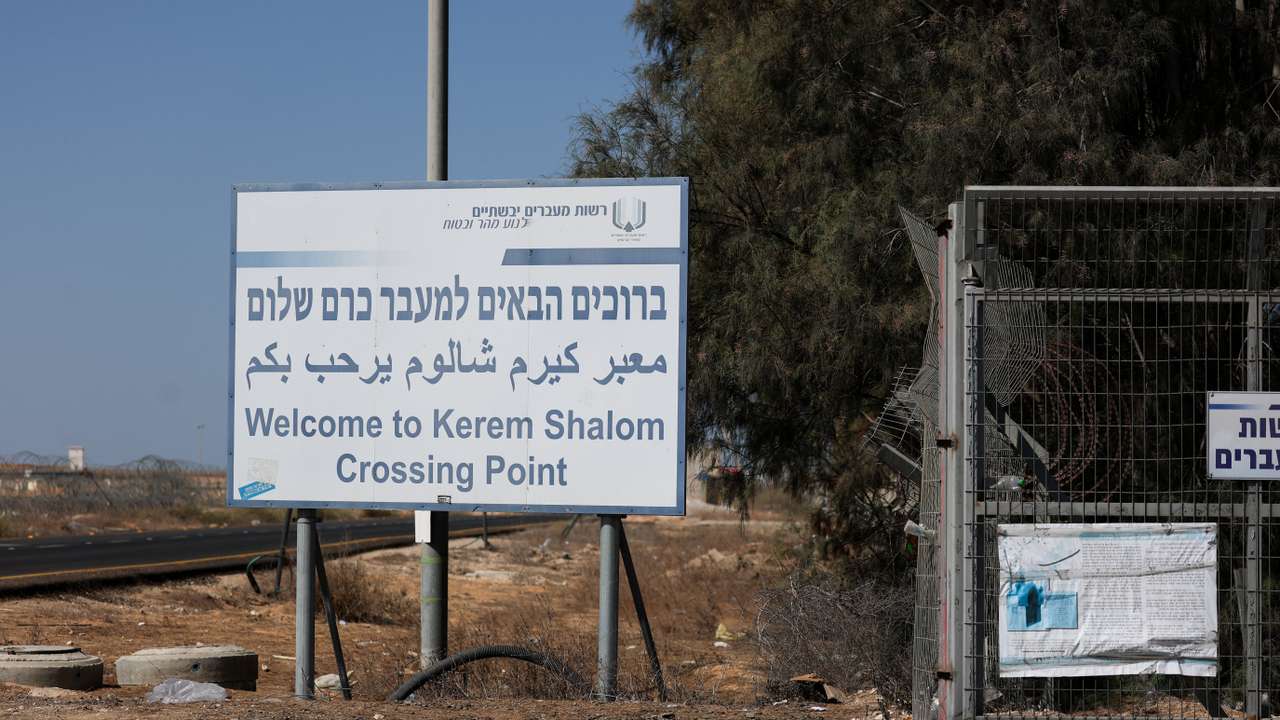 Trucks carrying aid wait at the Israeli side of the Kerem Shalom border crossing to southern Gaza