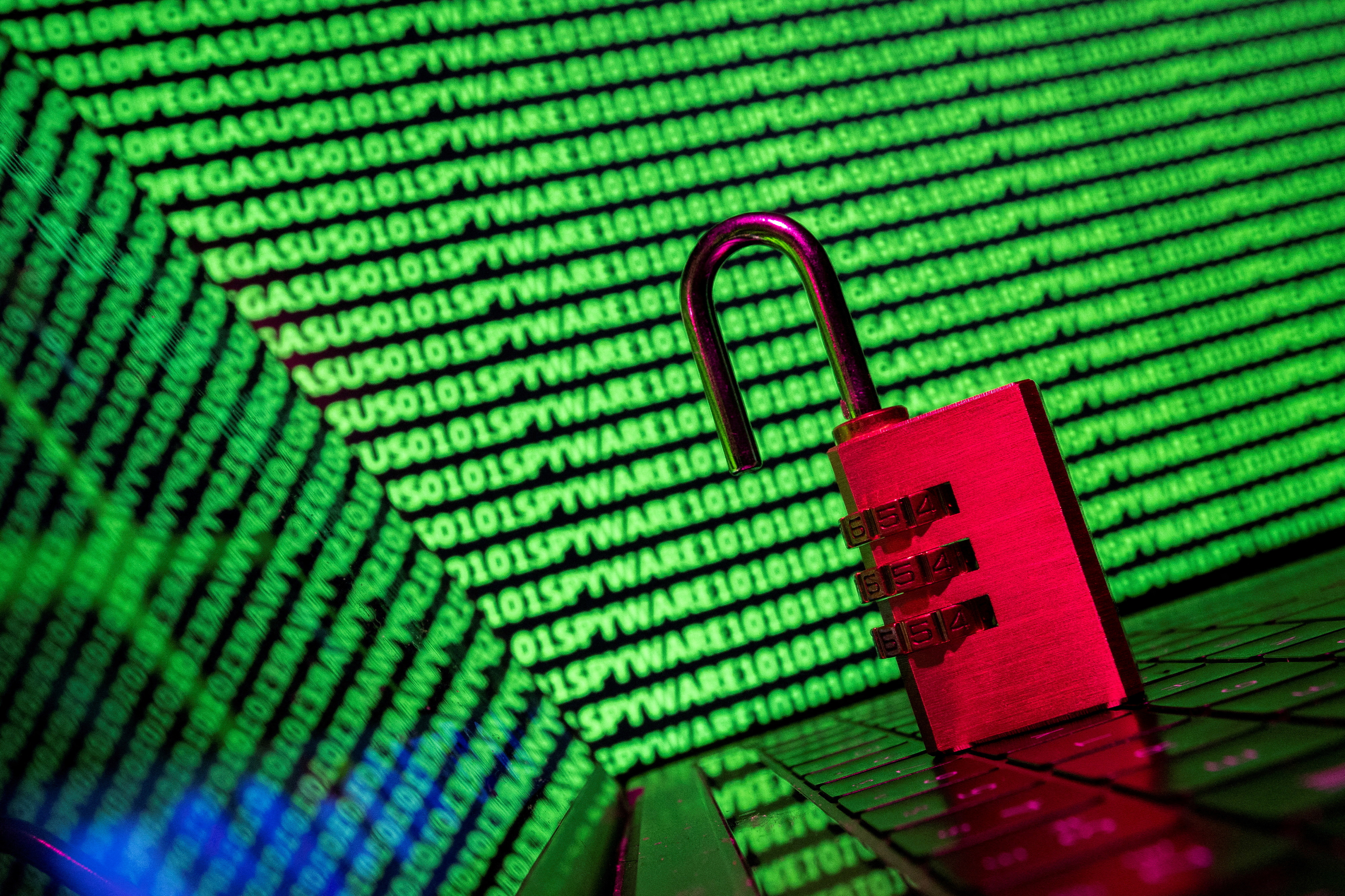 FILE PHOTO: Illustration shows a padlock in front of the word Spyware and binary code