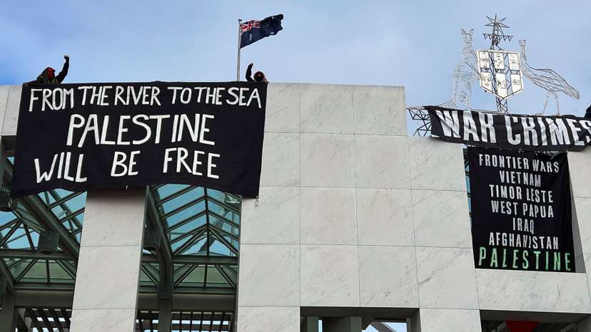 Pro-Palestinian protesters hang banners at the Parliament House in Canberra