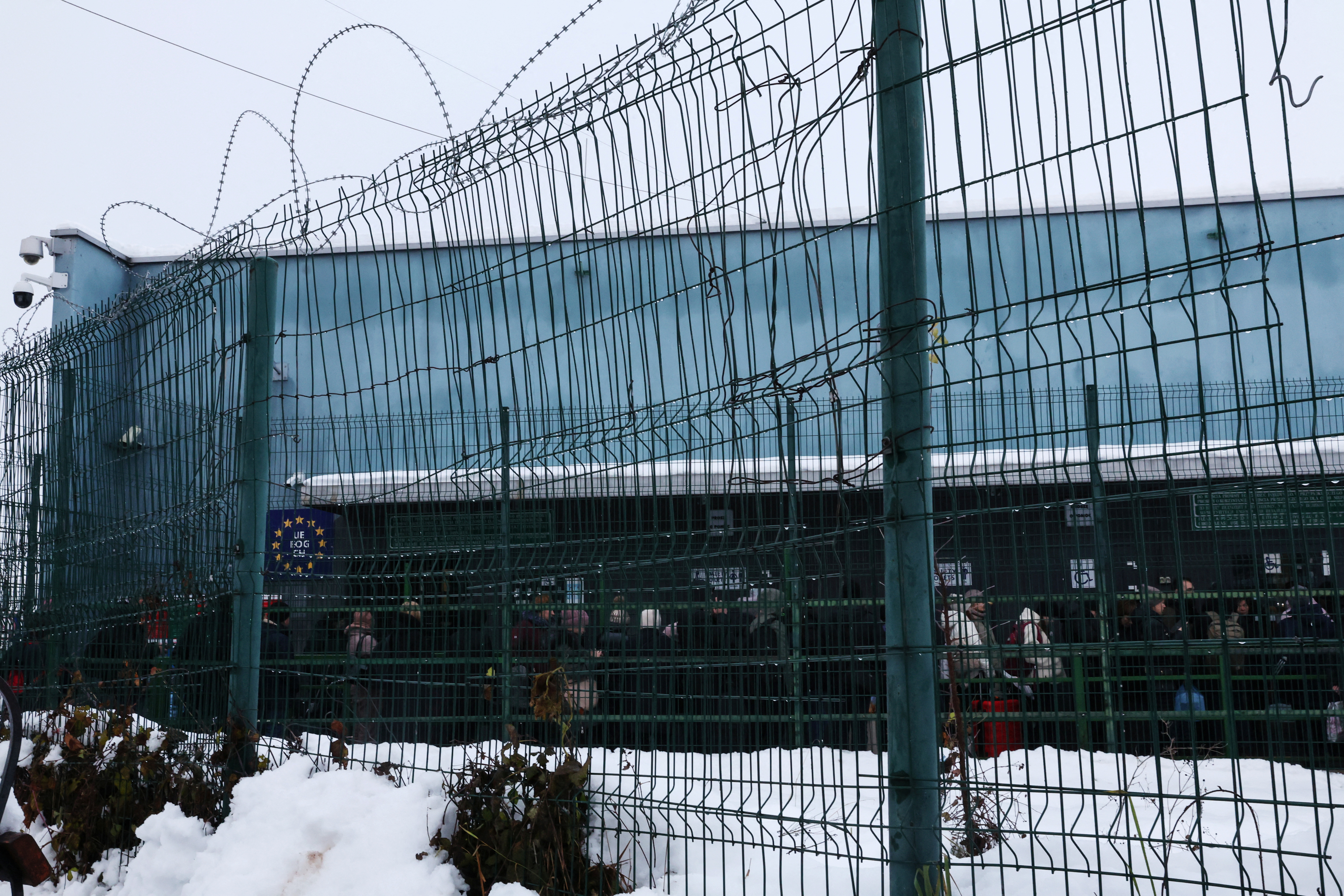 People wait in line to enter the Polish border control checkpoint, from Ukraine, in Medyka