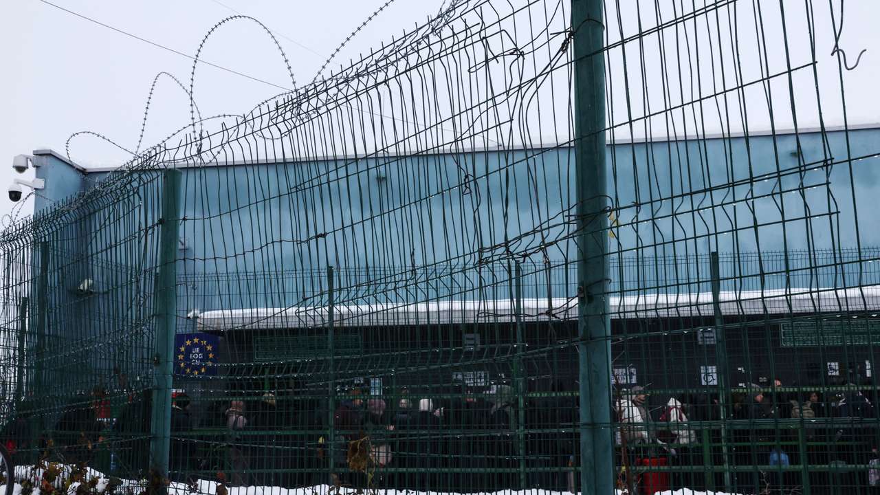 People wait in line to enter the Polish border control checkpoint, from Ukraine, in Medyka