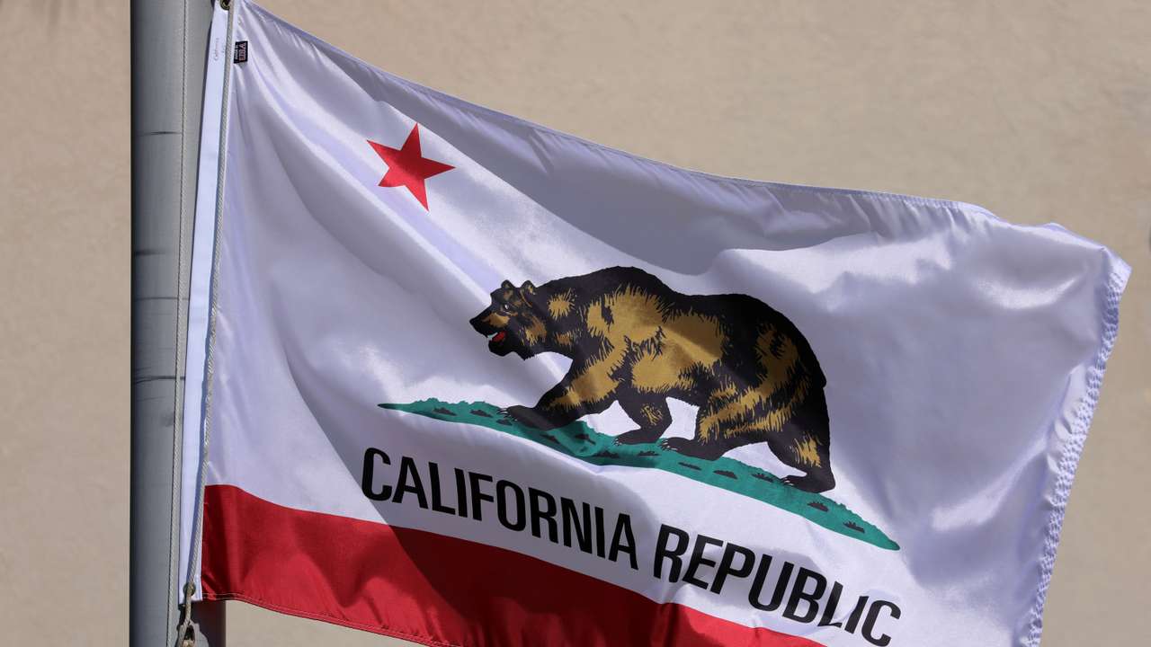 The state flag of California flies on a flag pole in San Diego