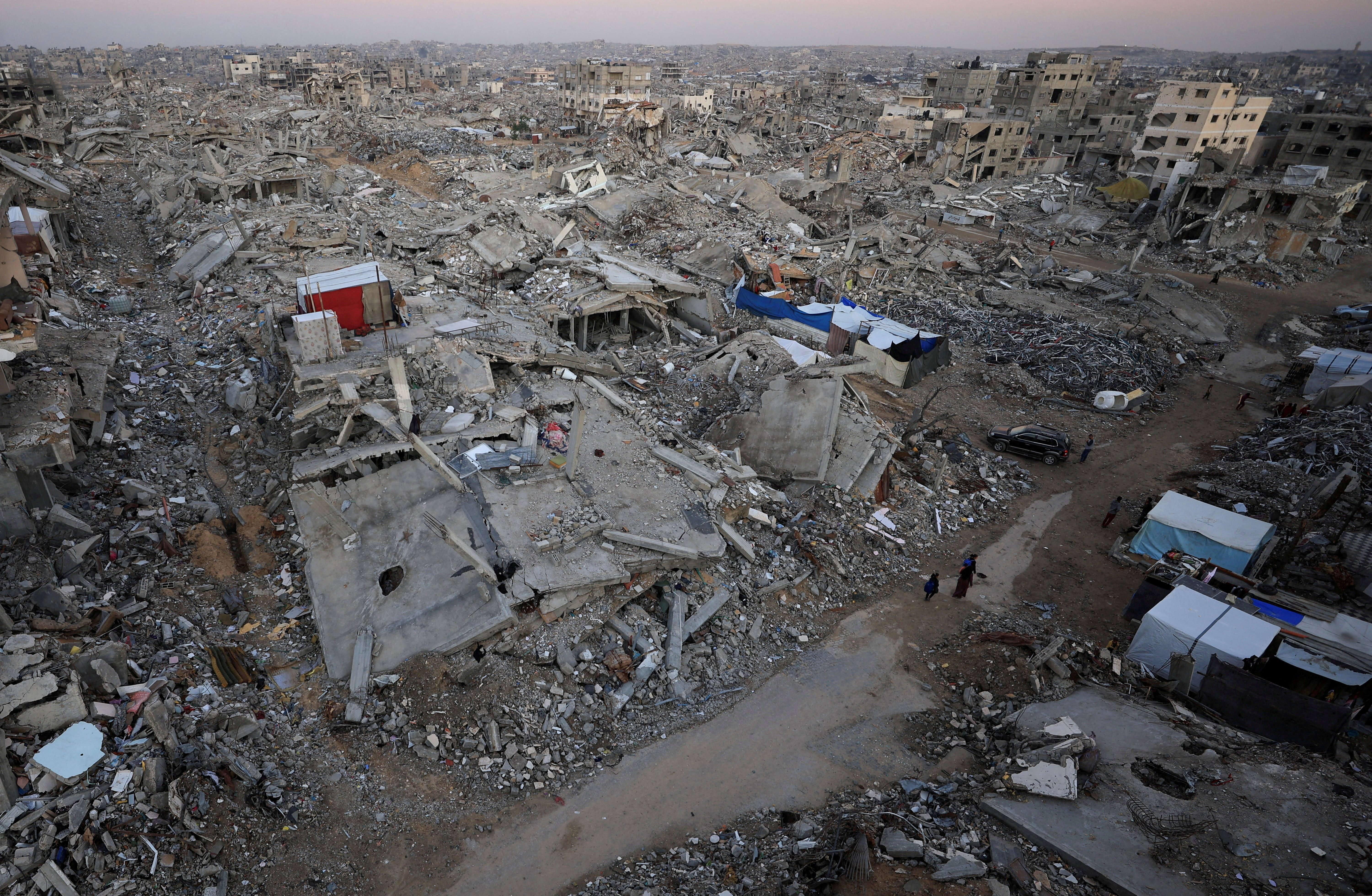 Palestinians stand near rubble from destroyed buildings, amid a ceasefire between Israel and Hamas, in Gaza City