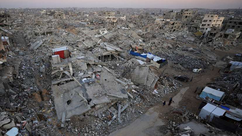 Palestinians stand near rubble from destroyed buildings, amid a ceasefire between Israel and Hamas, in Gaza City