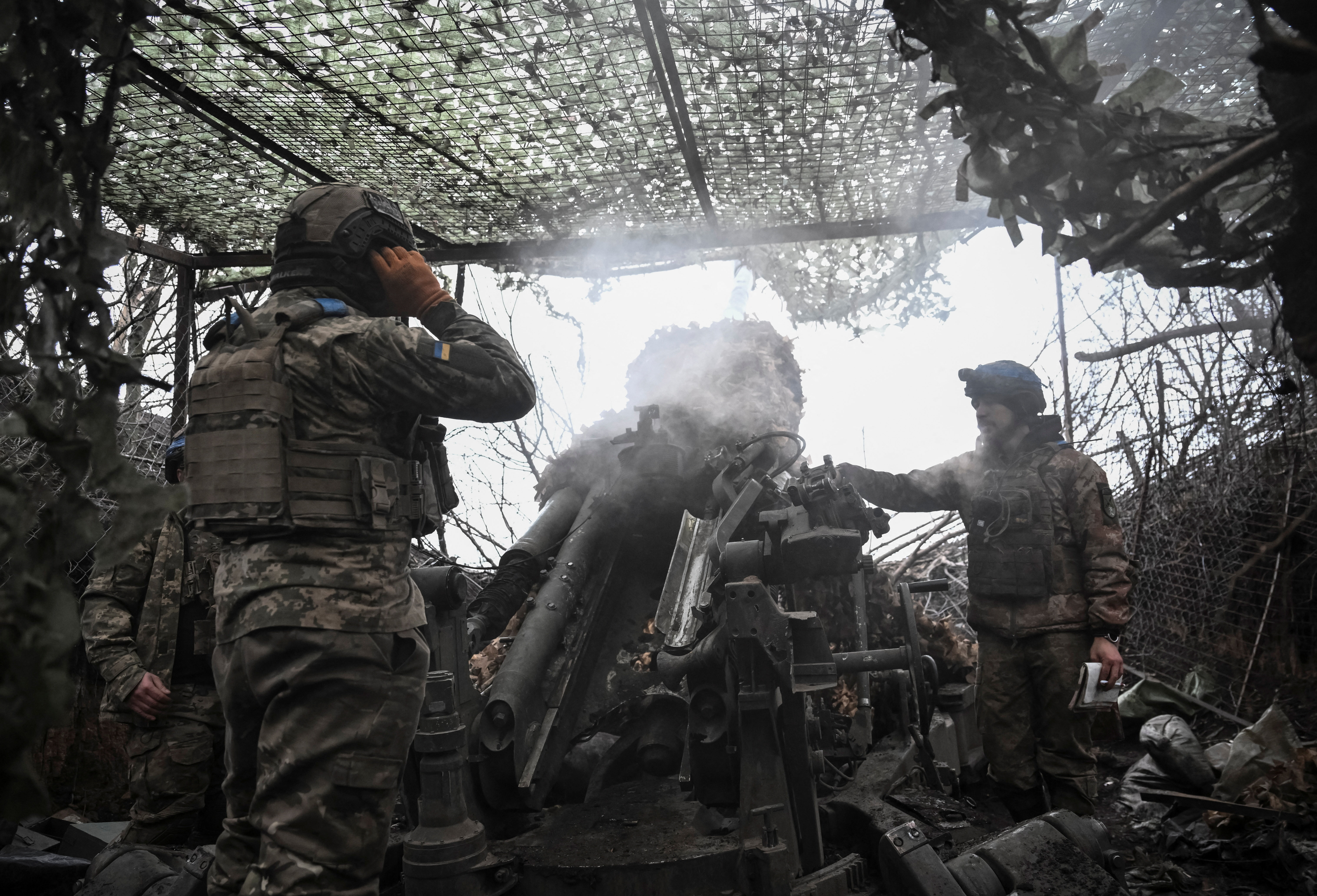 Ukrainian servicemen fire a howitzer towards Russian troops in Dnipropetrovsk region