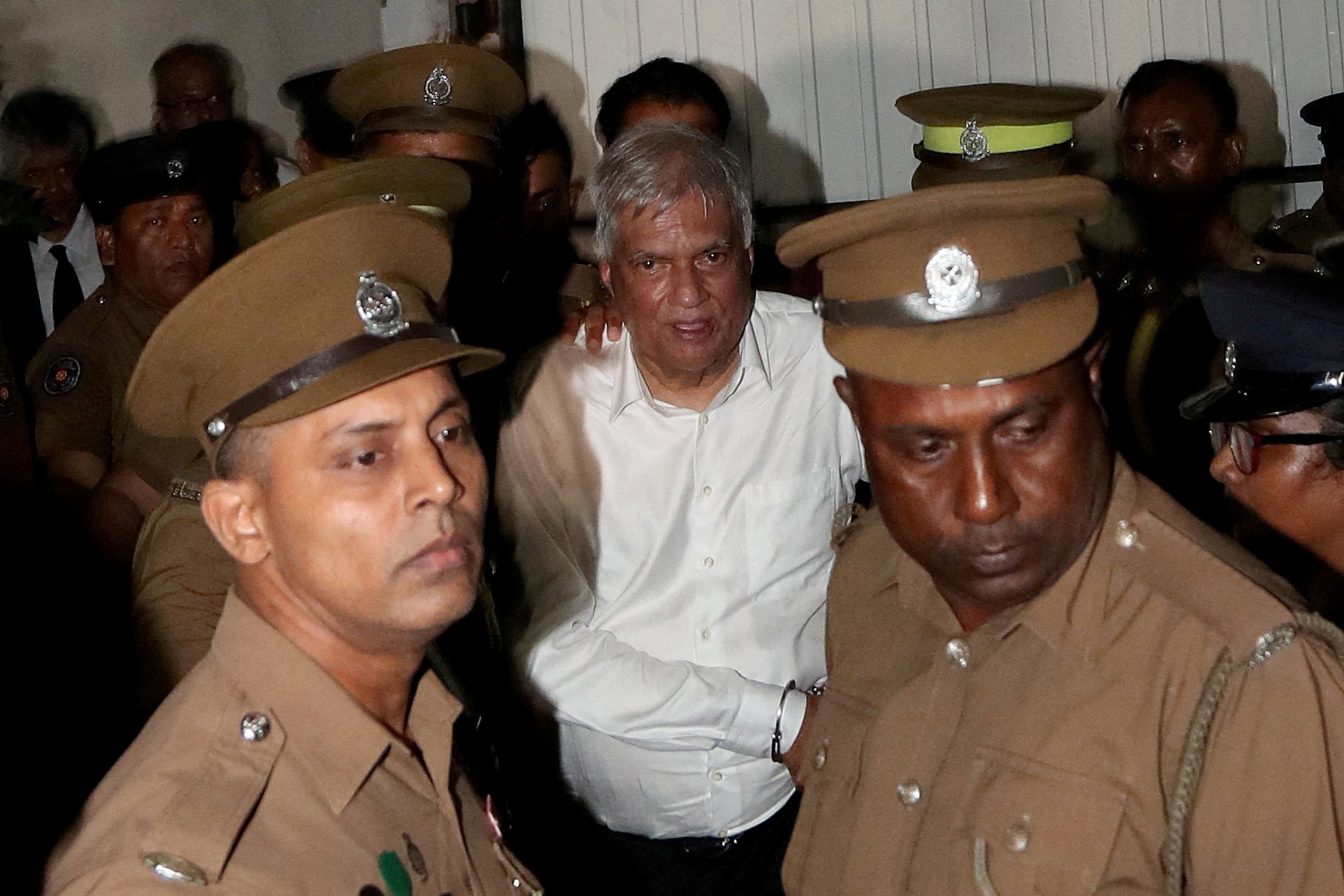 FILE PHOTO: Sri Lanka's former President Wickremesinghe is escorted by prison and police officials as he leaves the Magistrate’s Court in Colombo