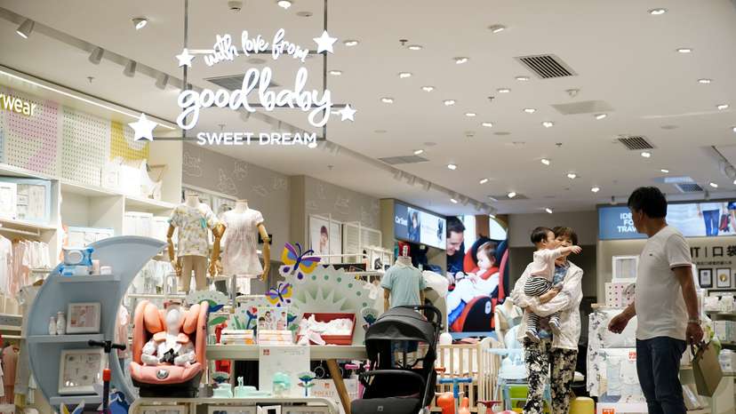 FILE PHOTO: Adult holding a baby walks at a store selling baby products in Shanghai
