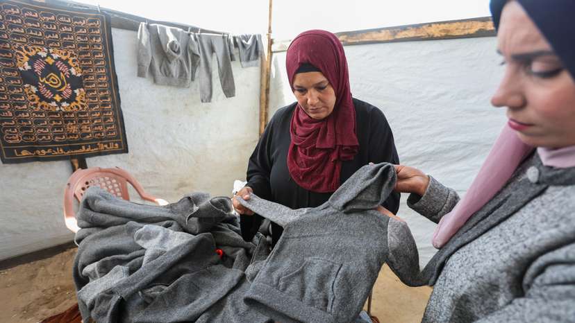Displaced Palestinians turn blanket into winter clothes to fight cold in Gaza