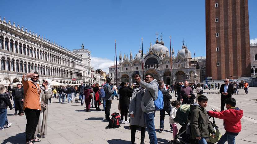FILE PHOTO: Tourists walk in St Mark's Square on the day Venice municipality introduces a new fee for day trippers
