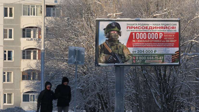 People walk along a street past a billboard promoting military service under the contract in Russian Armed Forces in the town of Gatchina
