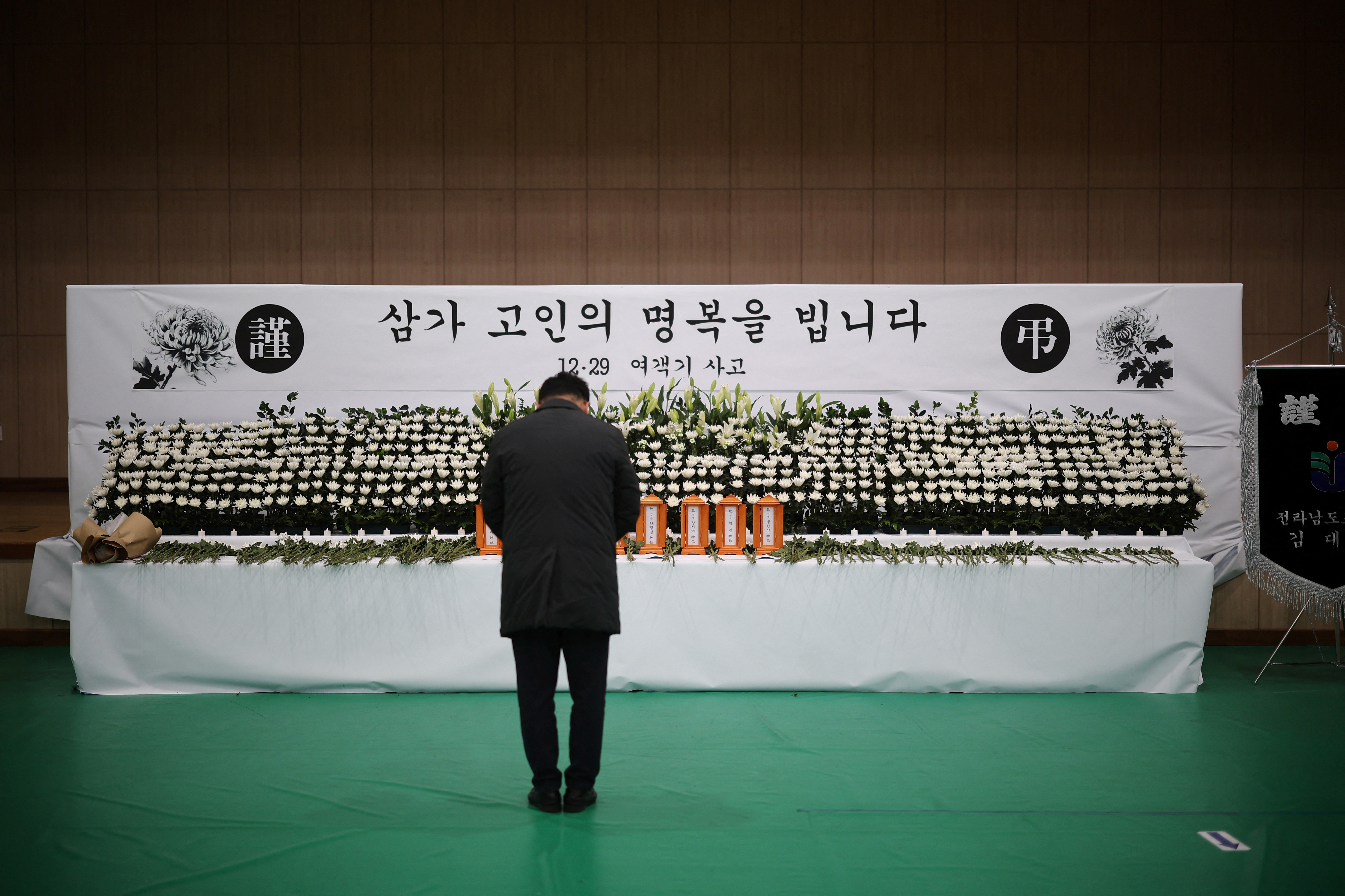A man mourns at a memorial altar for government officials of Jeollanam-do Office of Education and students who died in the Jeju Air crash at Muan International Airport, in Muan