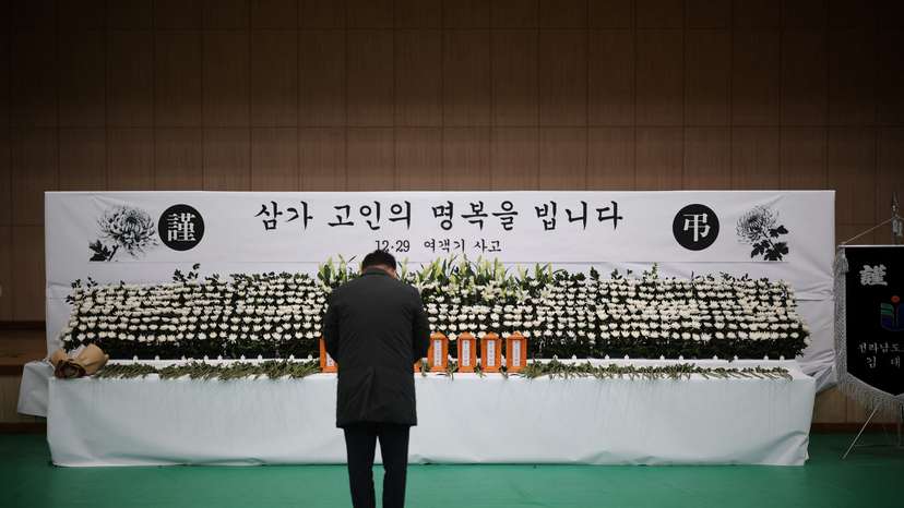 A man mourns at a memorial altar for government officials of Jeollanam-do Office of Education and students who died in the Jeju Air crash at Muan International Airport, in Muan