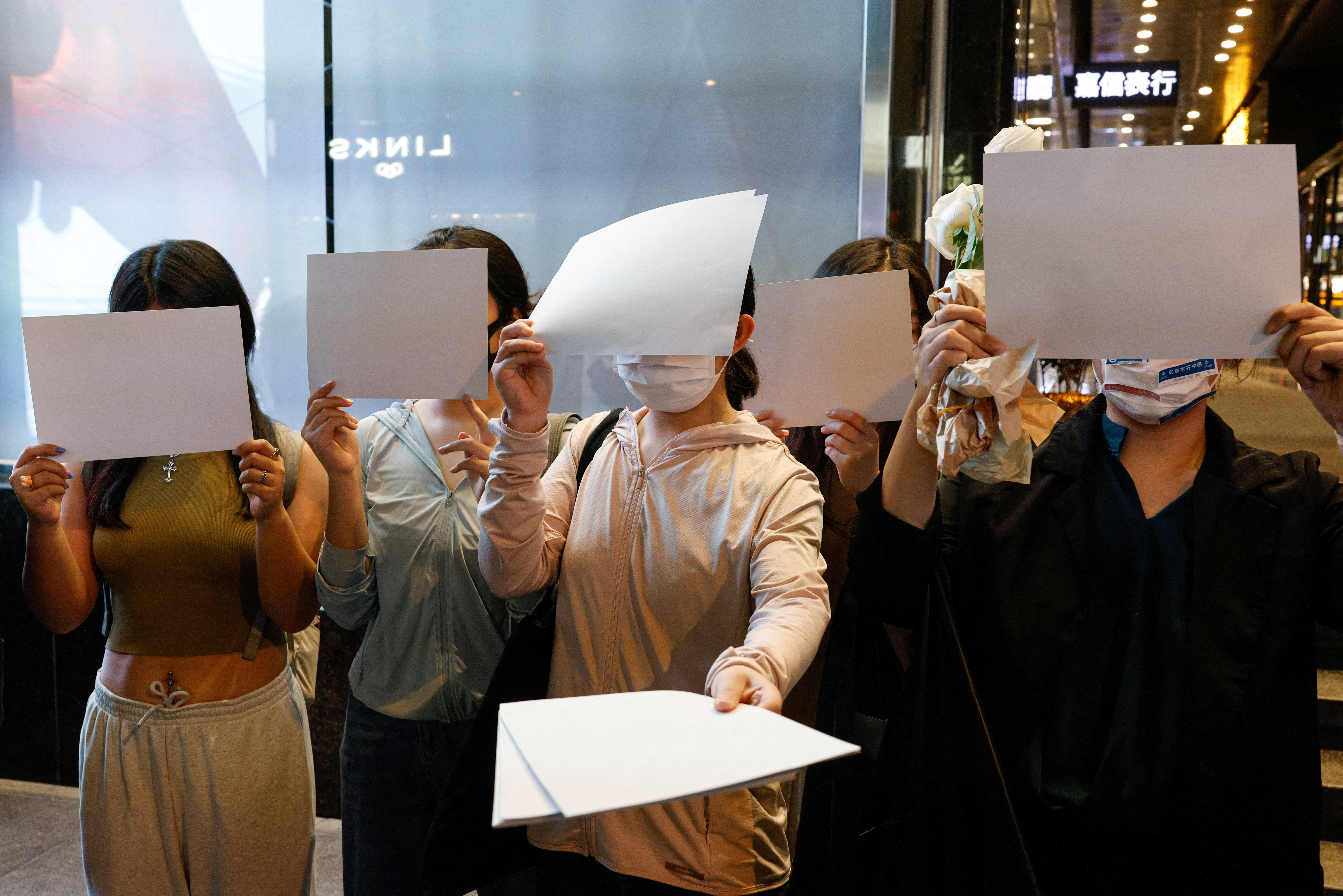 People hold white sheets of paper in protest over COVID-19 restrictions in mainland China, in Hong Kong