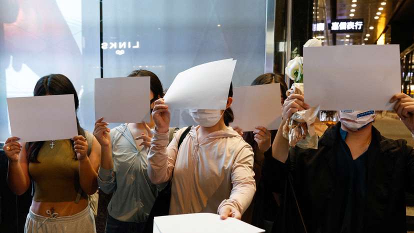 People hold white sheets of paper in protest over COVID-19 restrictions in mainland China, in Hong Kong