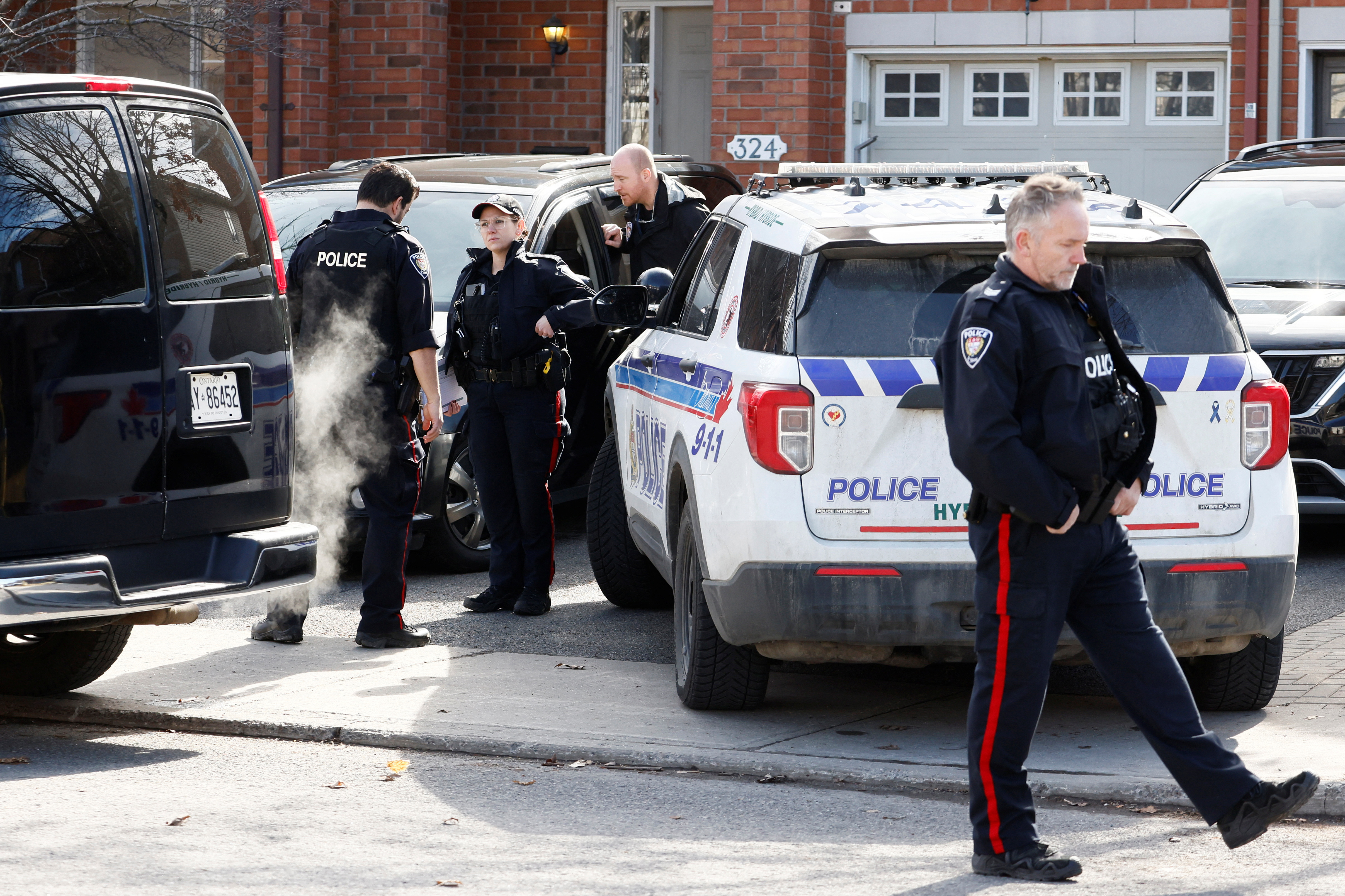 Ottawa Police Service officers surround a home after four children and two adults were found dead inside a neighbouring house in Ottawa