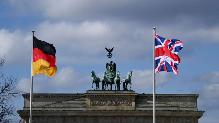 A German and a Union Jack flag fly at Brandenburg Gate, in Berlin