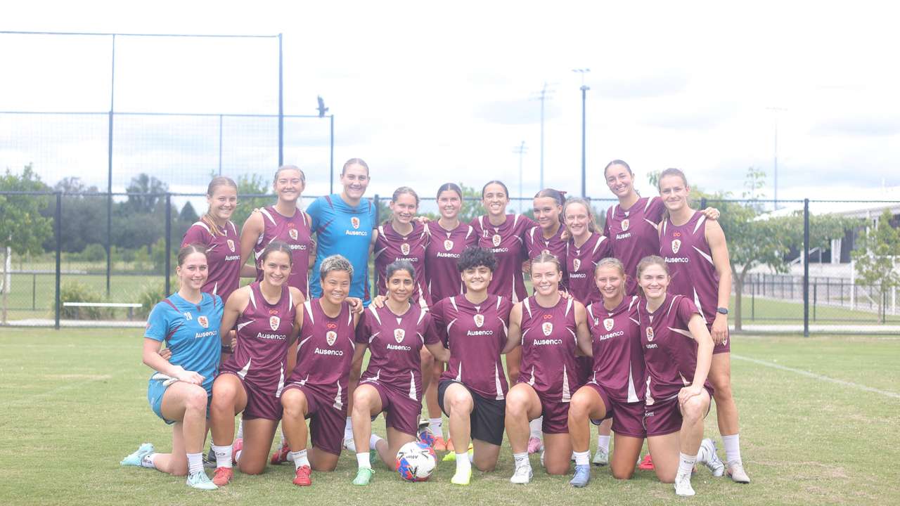 Iranian soccer players Atefeh Ramezanizadeh and Fatemeh Pasandideh pose for a photo with members of Brisbane Roar women's football club, in Brisbane