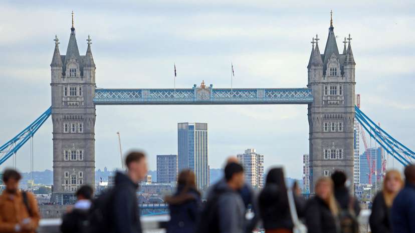 FILE PHOTO: People walk over London Bridge looking at a view of Tower Bridge in the City of London