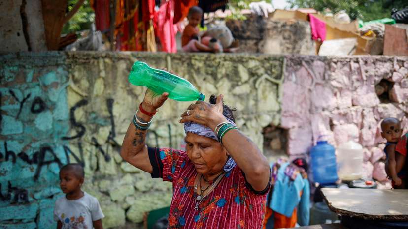 FILE PHOTO: Residents fill their containers with drinking water from a municipal tanker on a hot summer day in New Delhi