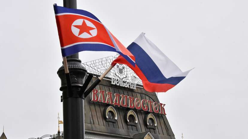State flags of Russia and North Korea fly in a street in Vladivostok