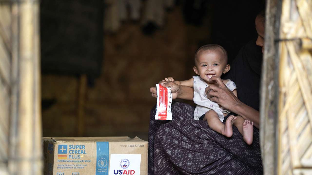 A Rohingya woman feeds nutrition supplements that have been provided by USAID, to a child at a refugee camp in Cox's Bazar
