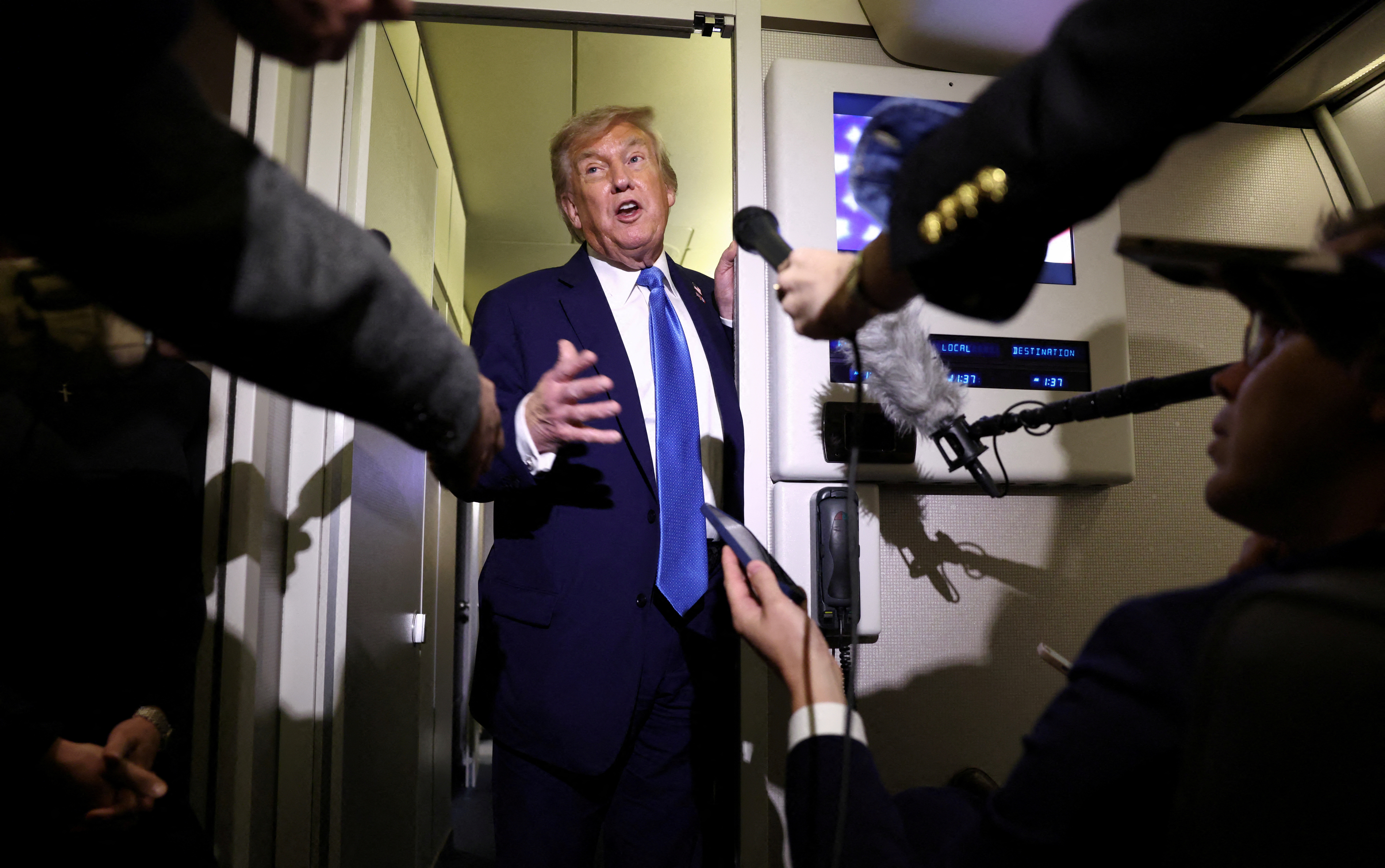 U.S. President Trump speaks to reporters aboard Air Force One on his way back to Washington