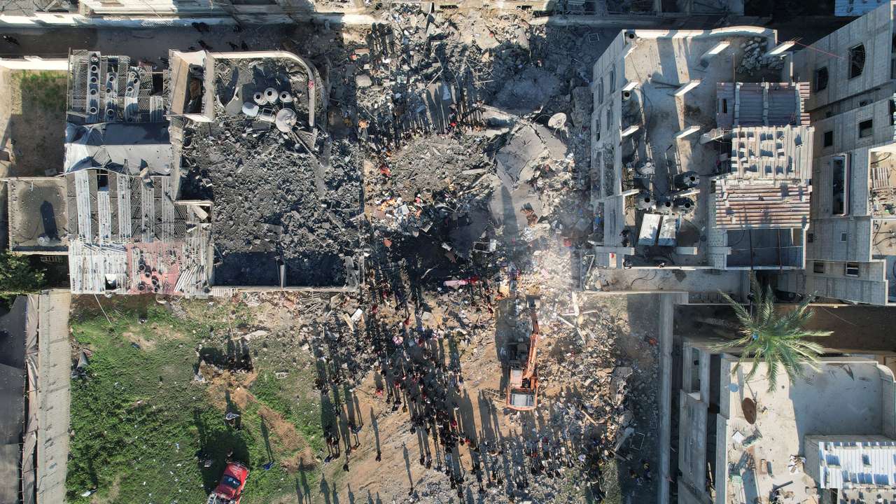 Palestinians gather at the site of an Israeli strike on a house, as the conflict between Israel and Hamas continues, in Rafah