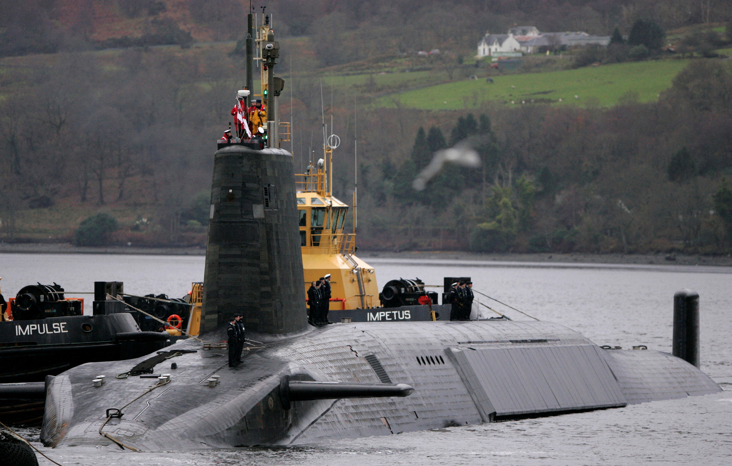 FILE PHOTO: Crew from HMS Vengeance stand on their vessel as they return along the Clyde river to the Faslane naval base near Glasgow