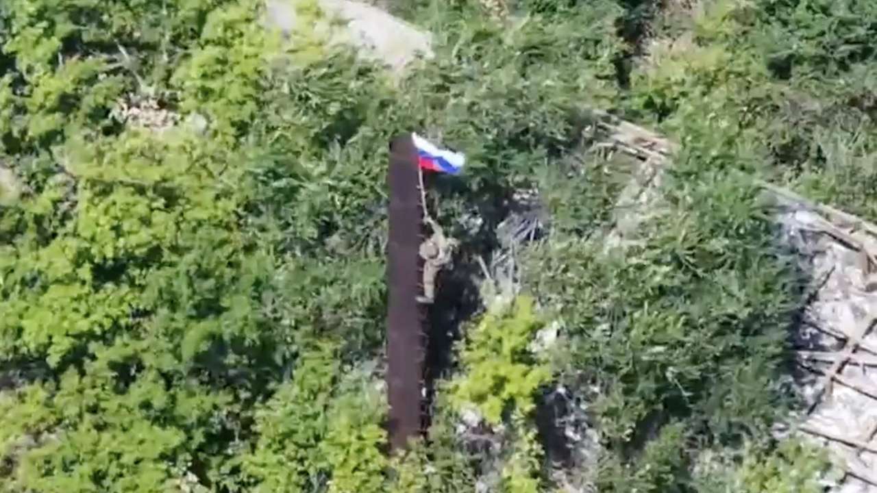 A still image from video released by Russian Defence Ministry shows what it said to be Russian soldier raising flag in Yablunivka in Donetsk region