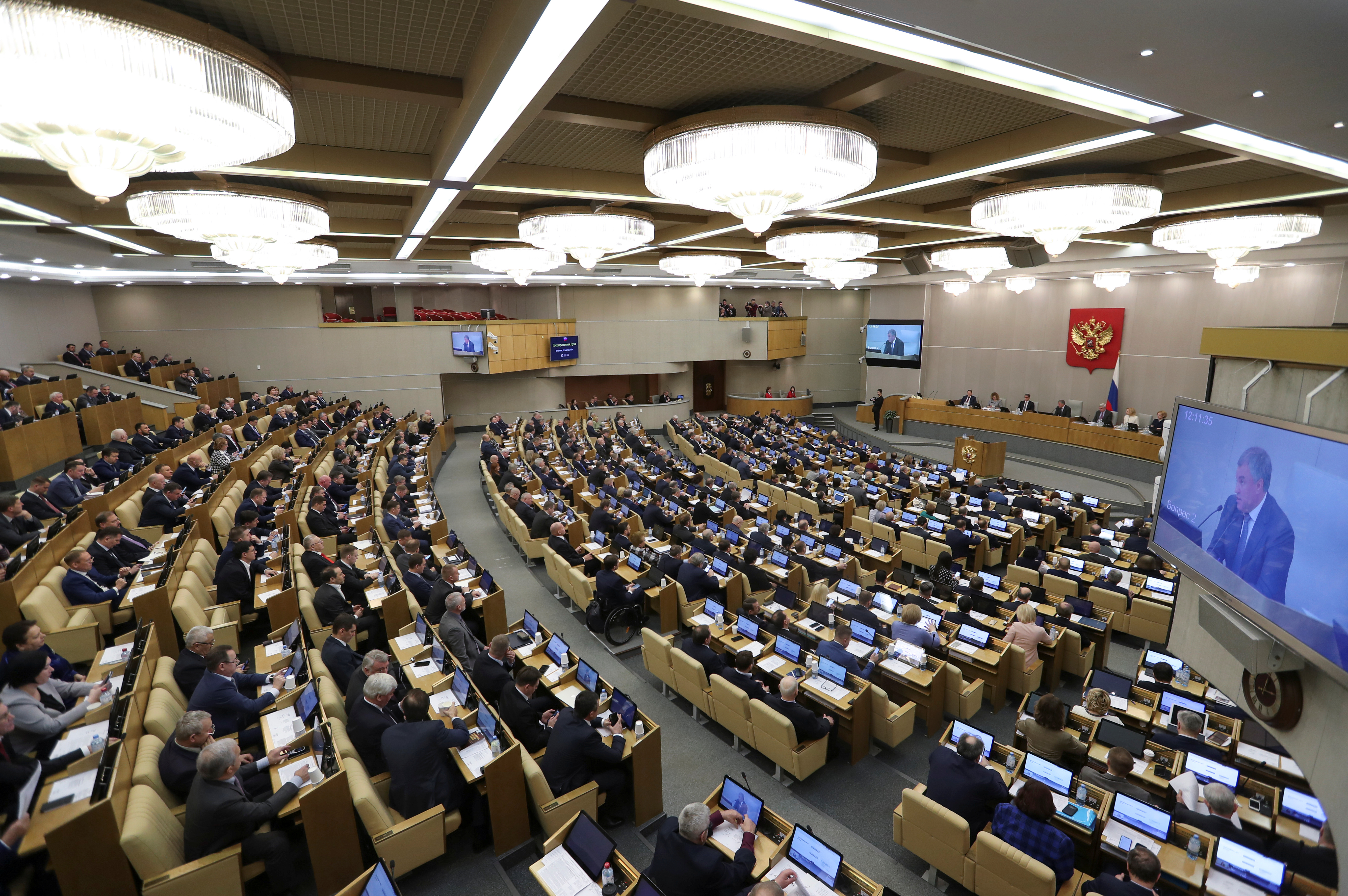 Members of Russia's lower house of parliament attend a session to consider constitutional changes in Moscow