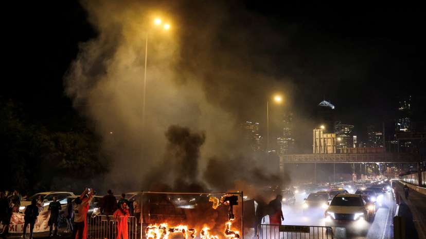 Fire blazes with the words in Hebrew, "Enough with the madness", calling for Gaza hostages release, in Tel Aviv Israel