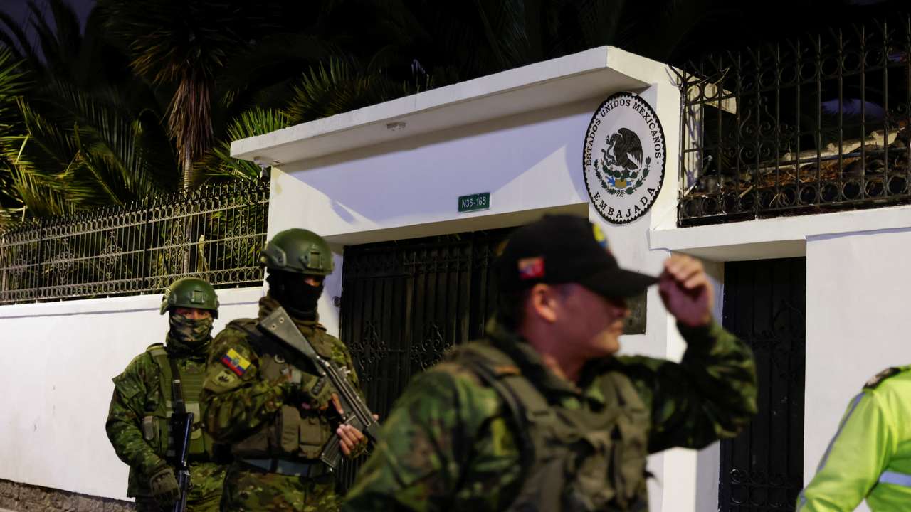 Police and military officials walk outside the Mexican embassy from where they forcibly removed the former Ecuador Vice President Jorge Glas in Quito