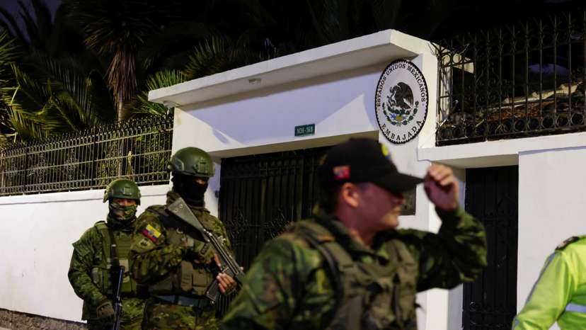 Police and military officials walk outside the Mexican embassy from where they forcibly removed the former Ecuador Vice President Jorge Glas in Quito